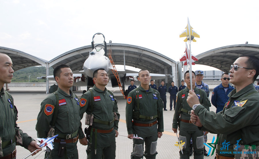 ↑艦載航空兵某部司令員戴明盟向飛行員演示空中飛行注意事項。
