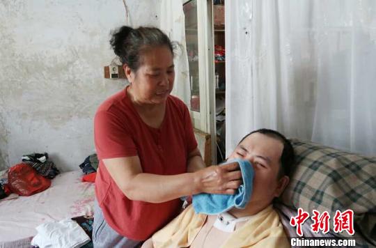 每次喂完食物后，梁青蘭都要仔細地幫兒子清理干凈?！∩忻鱾b 攝