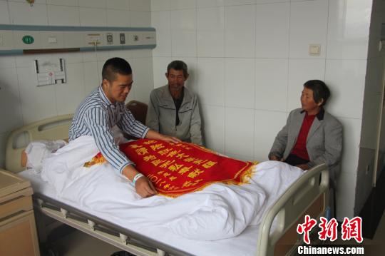 被救的李忠起、張總鳳夫婦看望受傷后的李運(yùn)飛?！⊥粲?攝