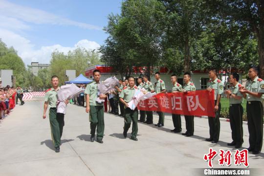 部隊(duì)官兵們迎接出院歸來(lái)的李運(yùn)飛(中)和其他消防戰(zhàn)士?！⊥粲?攝