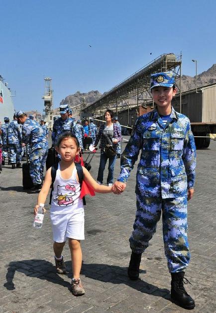 2015年3月，也門，海軍女戰(zhàn)士牽著一名小女孩的手準備登上軍艦。