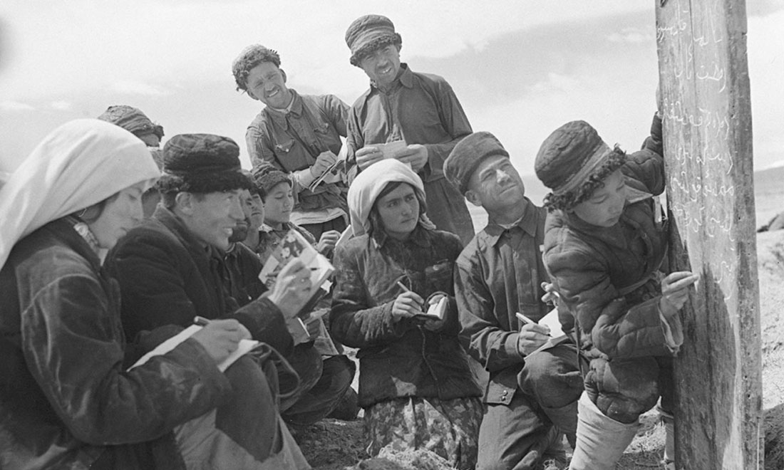 1960年6月，新疆慕士塔格峰下，大人們在小學生幫助下學習文化。新華社記者武純展攝