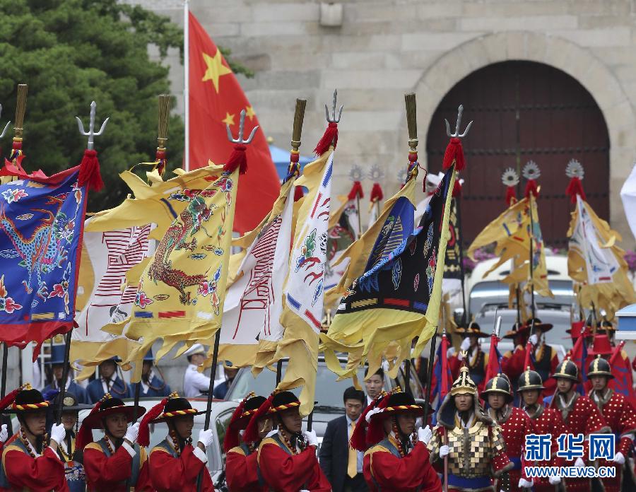 7月3日，韓國總統(tǒng)樸槿惠在青瓦臺總統(tǒng)府舉行隆重儀式，歡迎中國國家主席習(xí)近平對韓國進(jìn)行國事訪問。這是習(xí)近平的車隊在身著民族服裝的韓國禮儀隊伍引導(dǎo)下駛?cè)肭嗤吲_。新華社記者丁林?jǐn)z  