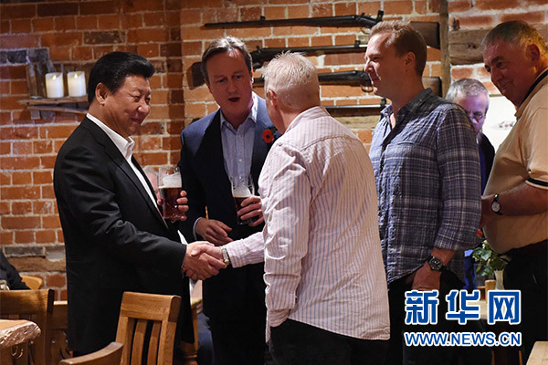這是習(xí)近平與卡梅倫飲啤酒，并同當(dāng)?shù)孛癖娊徽劇Ｐ氯A社記者 饒愛民 攝